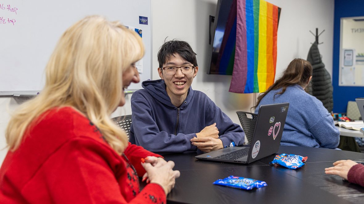 Students talk at a table during a club meeting