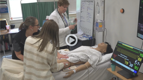 uma nursing students and professor work with a sim in video thumbnail