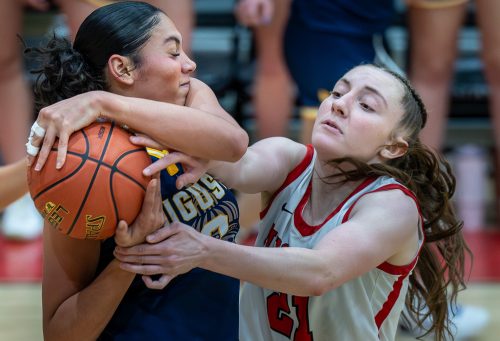 uma women's basketball player wresting ball from opponent photo credit russ dillingham