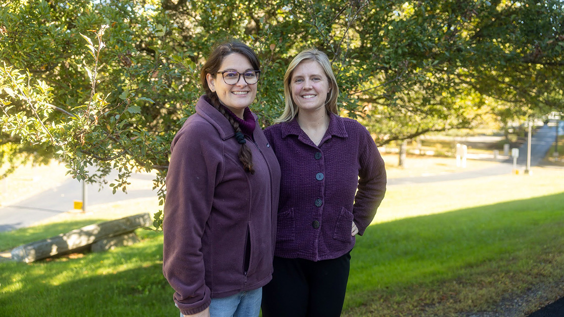 Two women wearing purple shirts